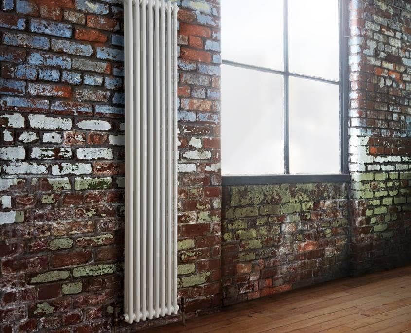 white radiator on brick wall